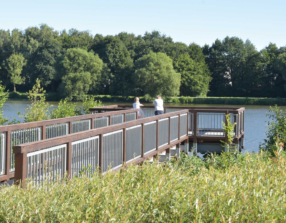 Aussichtsplattform am Obersee in Bielefeld. Zwei Menschen genießen dort den Blick auf den See.