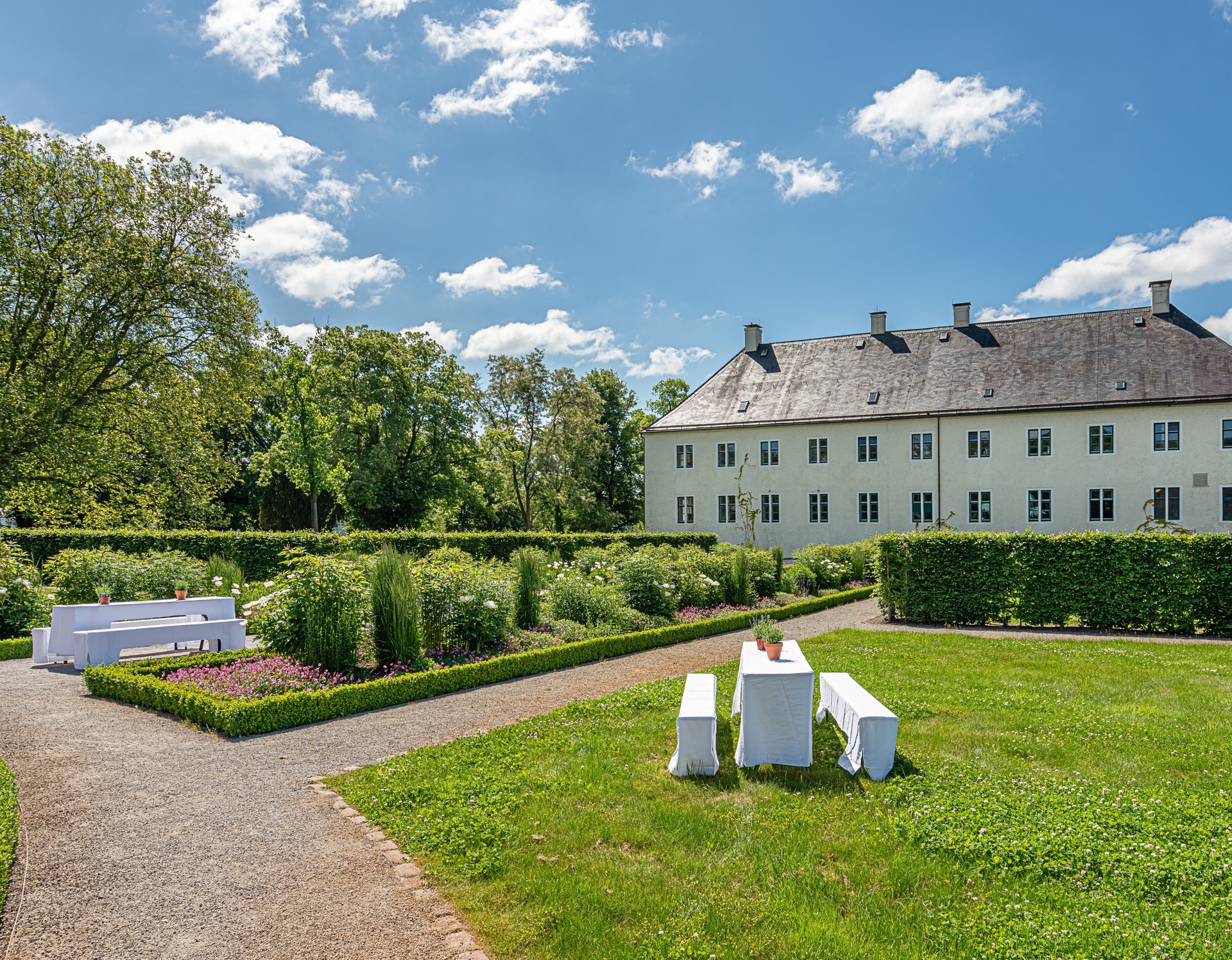 Schloss Benkhausen, Garten mit Tischen und Bänke mit weißen Hussen