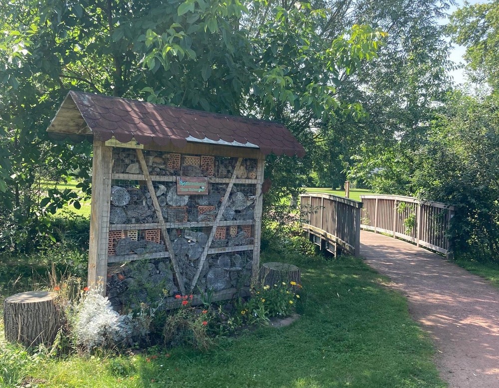 Ein Insektenhotel im Kurpark Bad Waldliesborn. Rechts befinden sich ein Weg und eine Fußgängerbrücke.