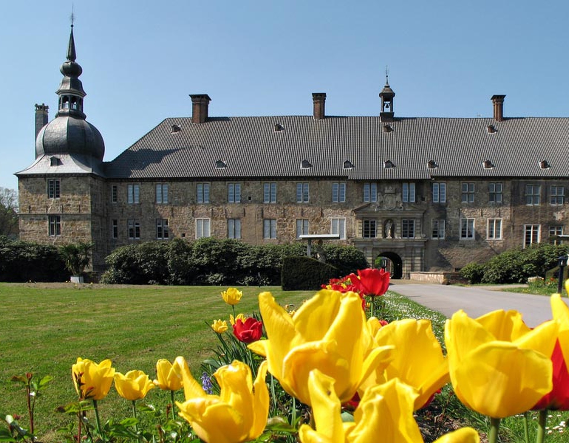 Tulpen im Innenhof der Vorburg. Im Hintergrund steht das Schloss Lembeck.
