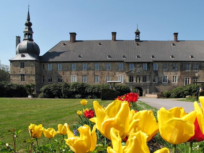 Tulpen im Innenhof der Vorburg. Im Hintergrund steht das Schloss Lembeck.