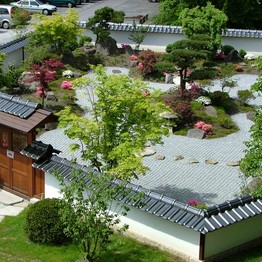 Luftbild des Japanischen Gartens in Bielefeld. In der Mitte des ummauerten Gartens befindet sich eine Kranichinsel mit einer zweistämmigen Formkiefer.