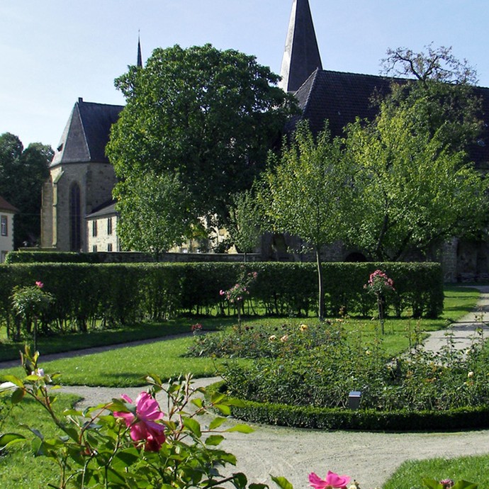 Der Rosengarten des rekonstruierten Klostergartens. Im Hintergrund befindet sich das Kloster mit der Kirche St. Christina. (öffnet vergrößerte Bildansicht)