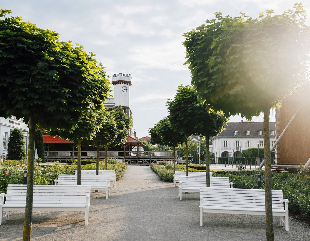 Bänke im Rosengarten des Kurparks Bad Salzuflen. Rechts sieht man ein Gradierwerk. Im Hintergrund davon befindet sich das Kurhaus.