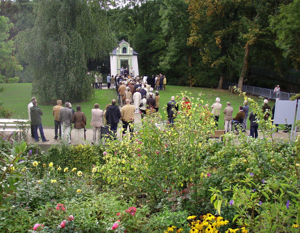 Vor dem klassizistischen Gartenhaus "Twiete 6" in den Arnsberger Bürgergärten steht eine größere Gruppe Menschen.