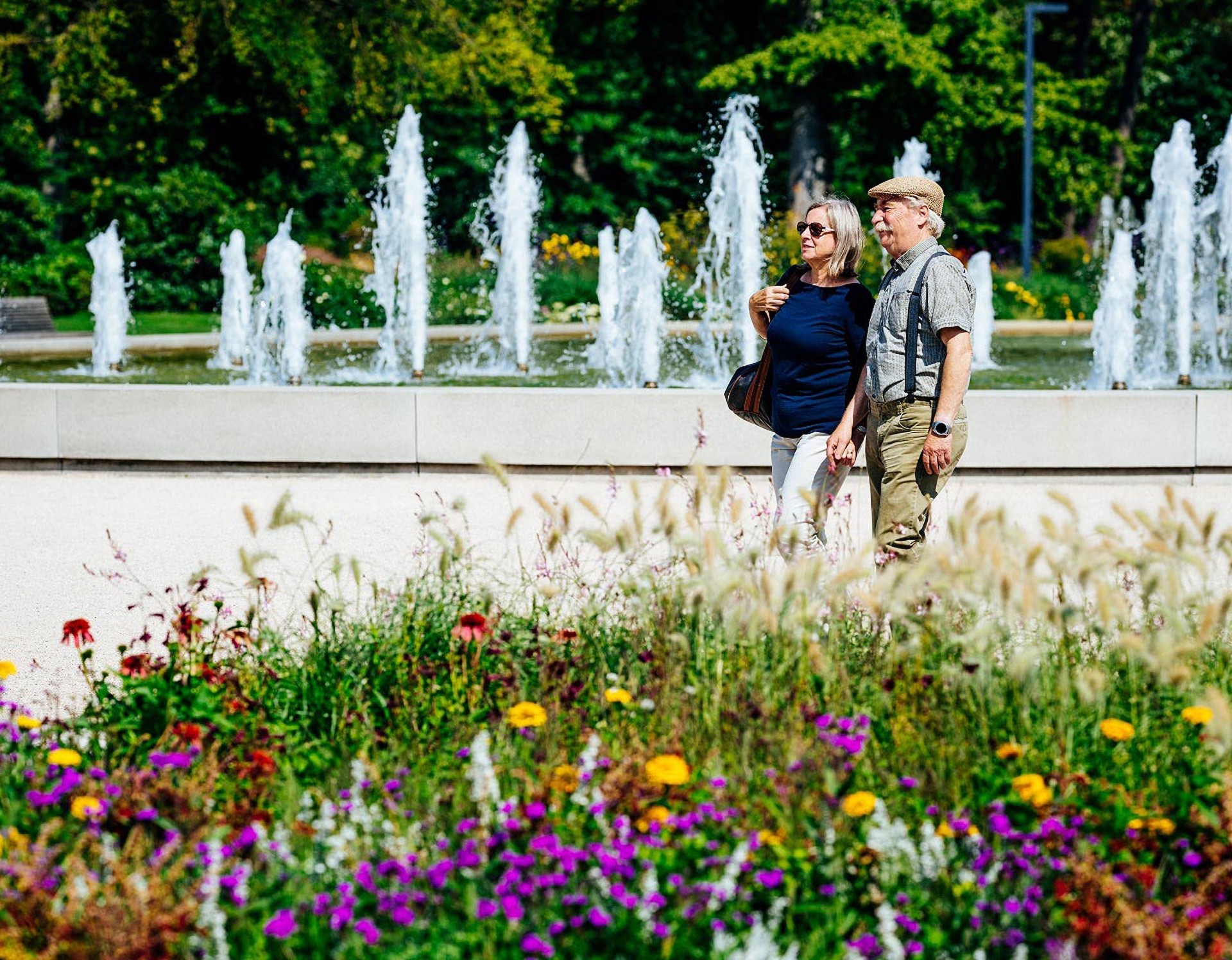 Ein älteres Paar steht vor der NIEWELS-Fontäne. Sie wurde der Landesgartenschau Bad Lippspringe geschenkt und empfängt die Gäste im Park.