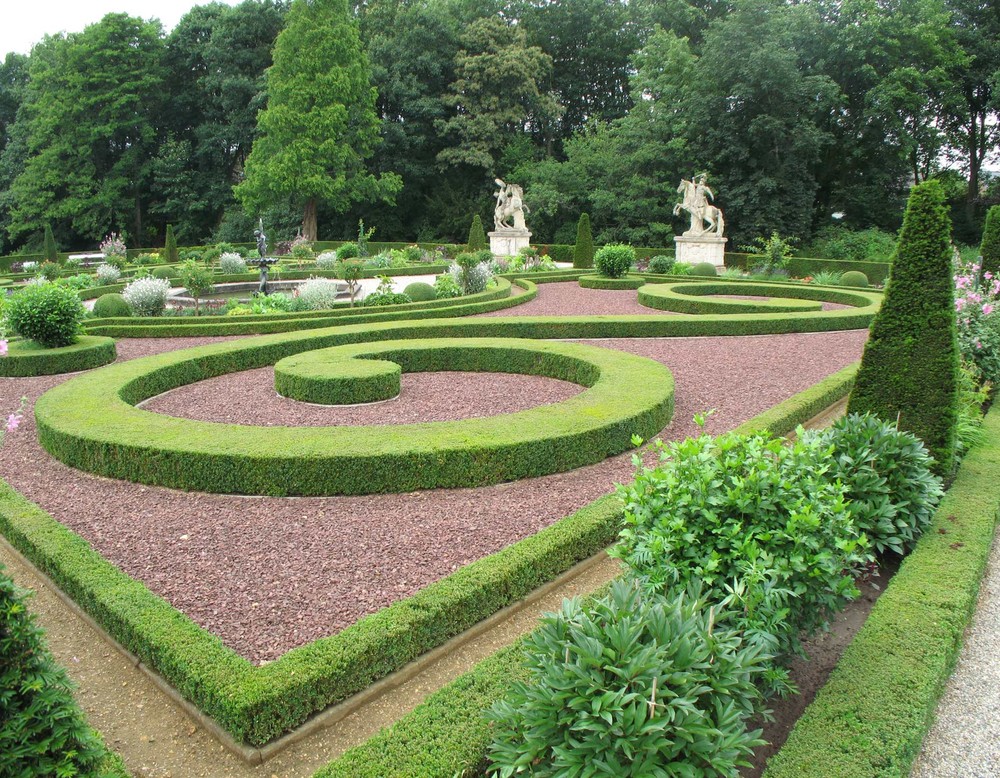 Das Busquett im Park der Wasserburg. In der Mitte befindet sich ein Brunnen. Am hinteren Ende stehen zwei Reiterstatuen.