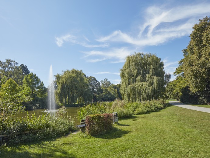 Fontaine neben Wiese mit Bäumen im Nordpark Bielefeld.