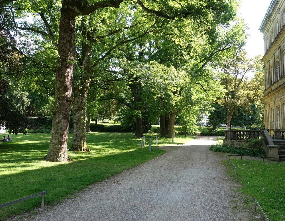 Der Fußweg des Palaisgartens auf Höhe der Hochschule für Musik. Rechts ist die Fassade der Hochschule zu sehen.