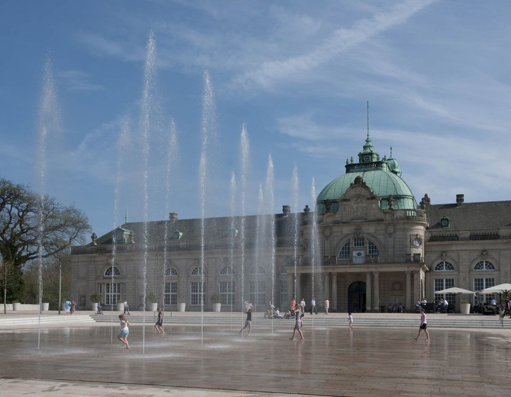 Das Wasserfontänenfeld auf dem Kurhausplatz des Kurparks Bad Oeynhausen. Im Hintergrund sieht man den Kaiserpalais.