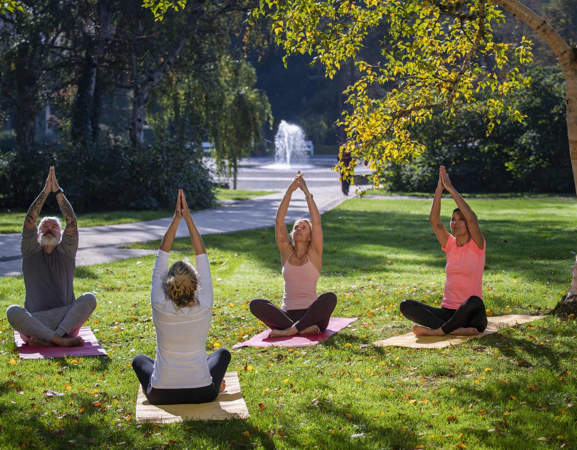 Eine Gruppe nimmt an einem Yogakurs im Kurpark Bad Sassendorf teil.